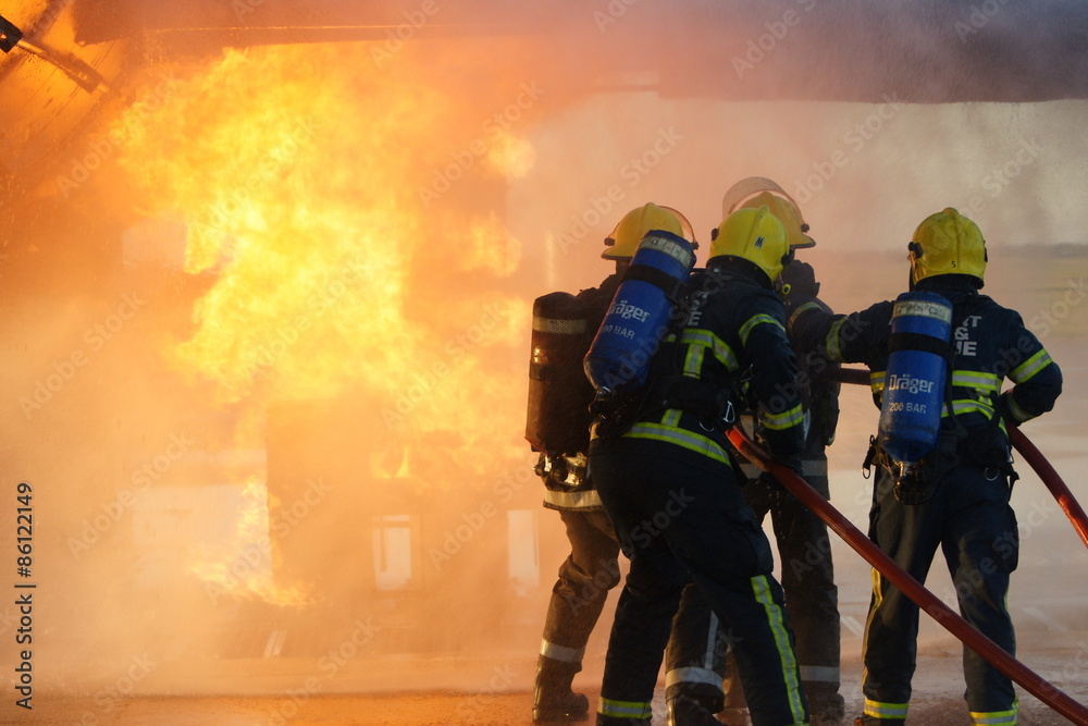Fototapeta premium firefighters fighting large factory fire
