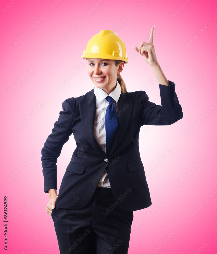 Young businesswoman with hard hat against gradient Young businesswoman with hard hat against gradient