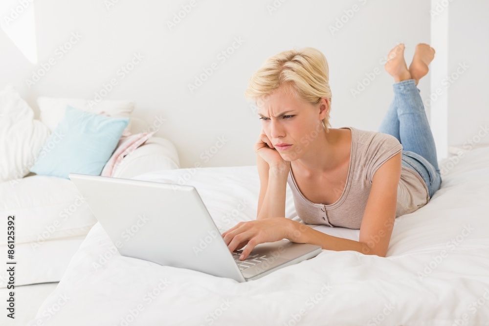Serious blonde woman using laptop Serious blonde woman using laptop