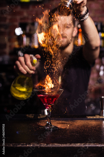 The bartender makes a cocktail of fire. photo