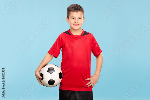 Little boy in a red jersey holding a football