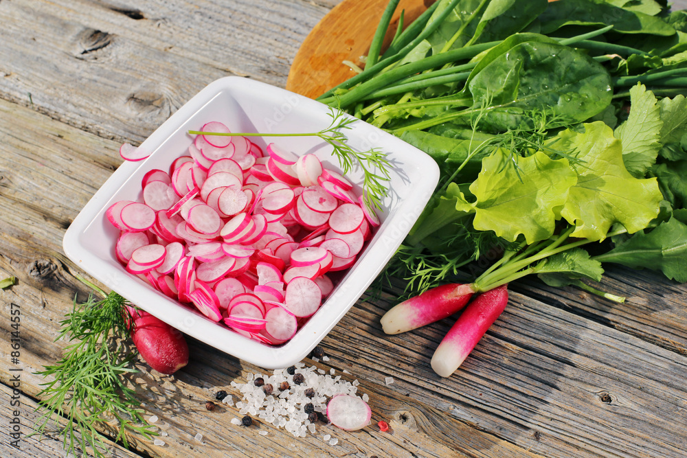 Plate of slice radishes on wooden table Plate of slice radishes on wooden table