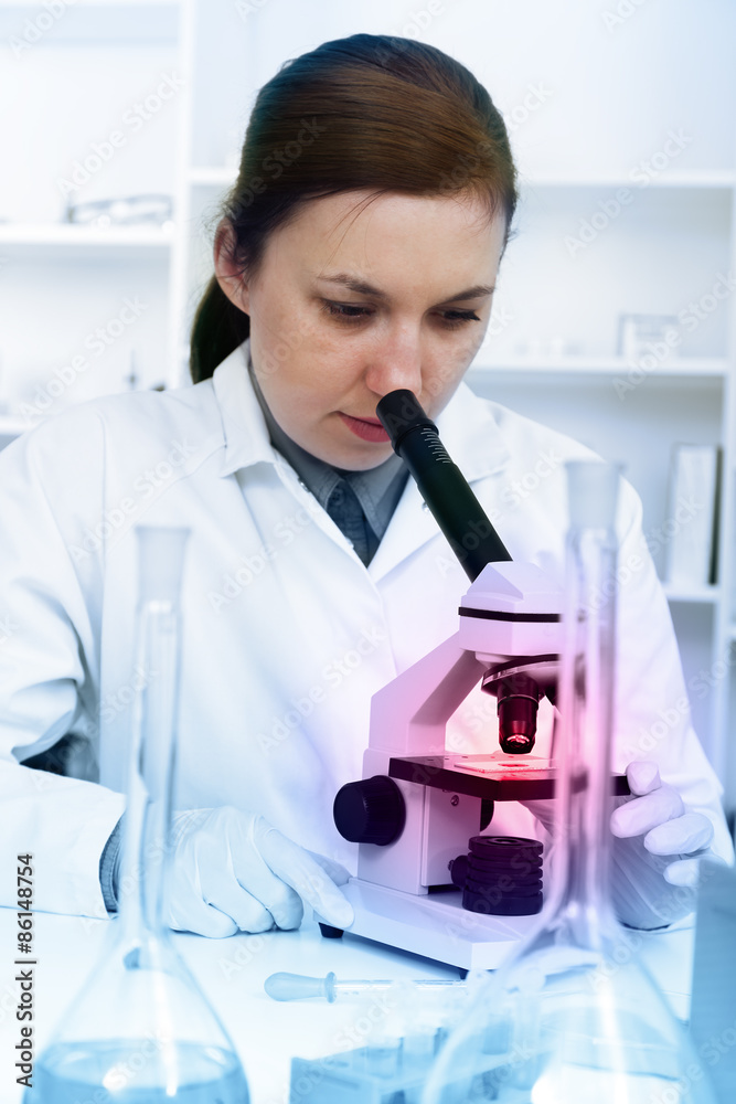 Serious female chemist working in laboratory Serious female chemist working in laboratory