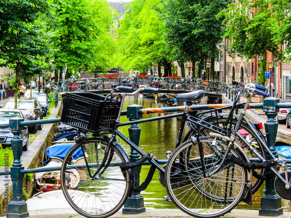 The bicycles parked on the bank of the channel, Amsterdam, Netherlands
