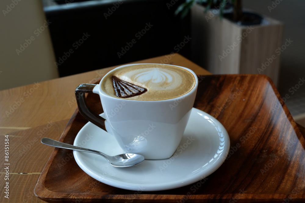 Fototapeta Filiżanka pienista cappuccino na drewnianym stole
