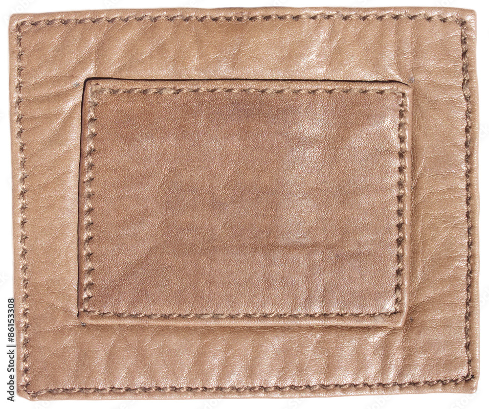 Blank leather label with stitches. Background texture.