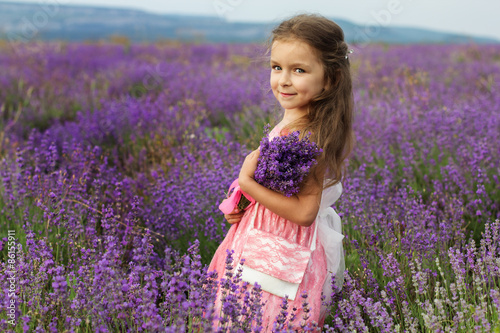Cute little child girl in lavender field with bouquet