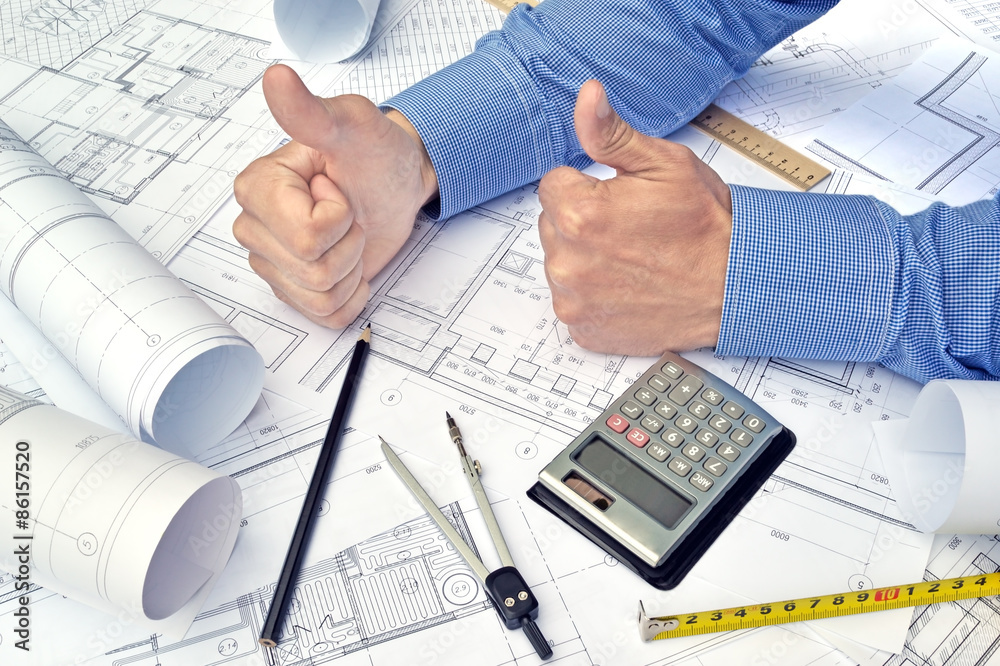 Hands of engineer working with the tool on project drawings background Hands of engineer working with the tool on project drawings background