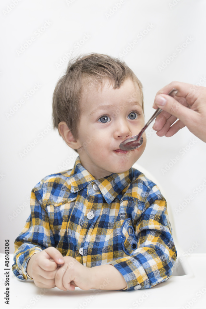 Mother feeding little boy baby food Mother feeding little boy baby food