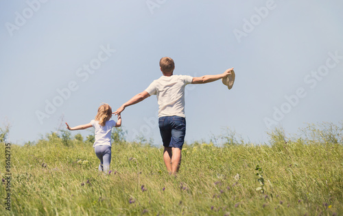 Father with the daughter running on the field
