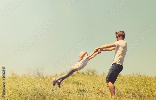 Father and daughter spinnig outdoor, tinted photo photo