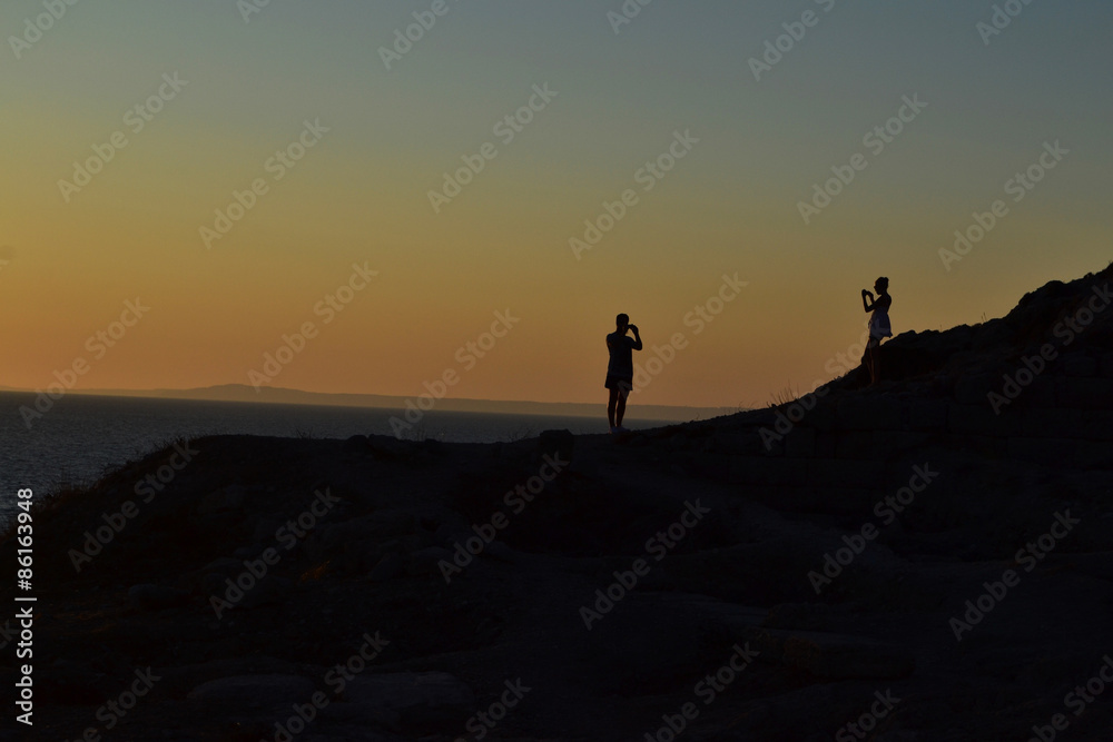 Couple taking photos each other at sunset Couple taking photos each other at sunset