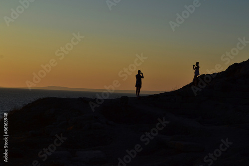 Couple taking photos each other at sunset