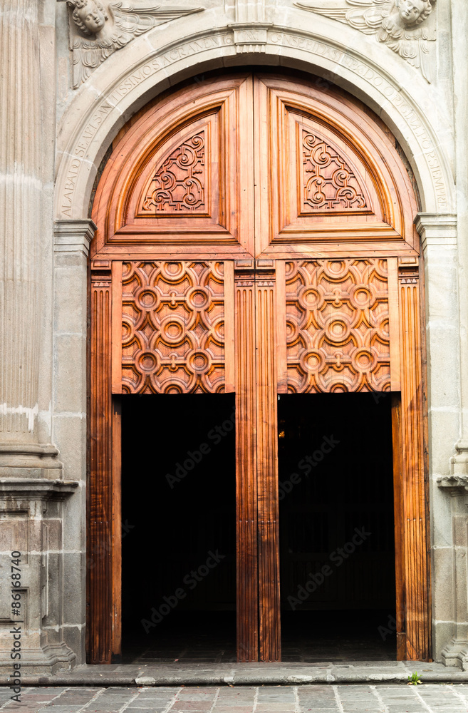 Giant wooden gate with smaller doors integrated on massive concrete style building