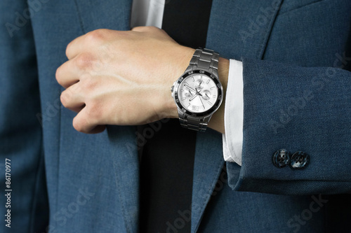 The businessman's photo in a suit. A hand with hours