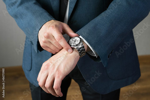 The businessman's photo in a suit. A hand with hours