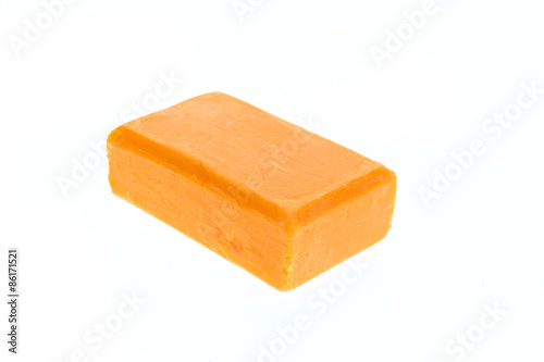 Close up bar of orange carrot soap isolated on white