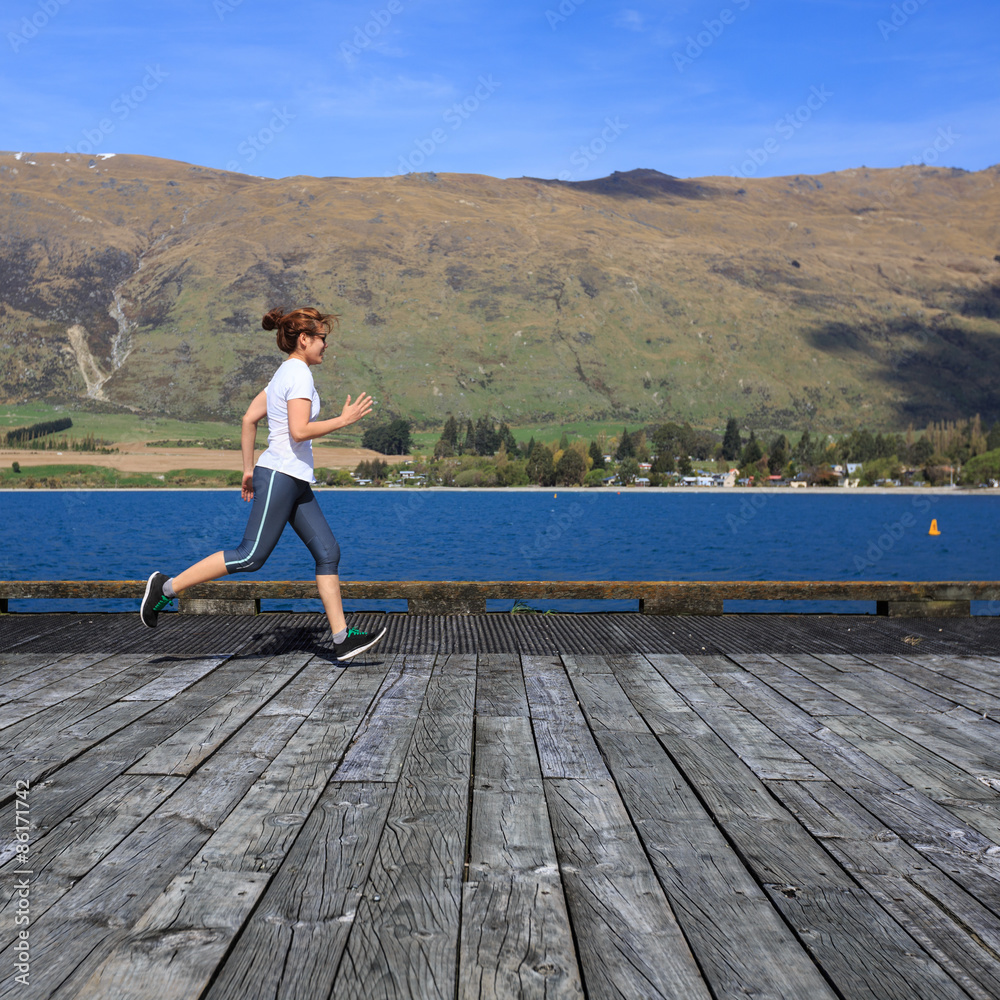 Young adult woman running on pier