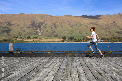 Young adult woman running on pier
