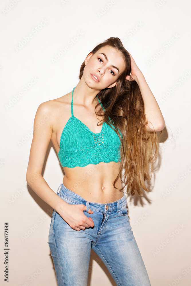 Attractive young woman in turquoise crochet top and jeans Attractive young woman in turquoise crochet top and jeans
