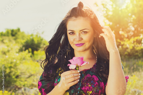 Beautiful young boho woman with pink rose