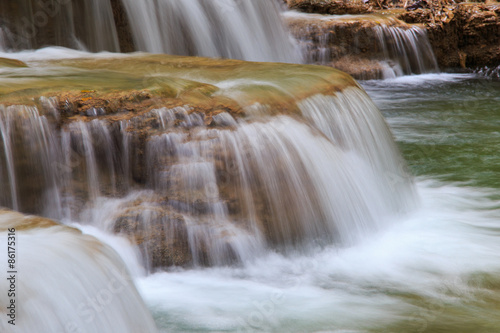 Water flowing over rocks in waterfall cascade in a forest