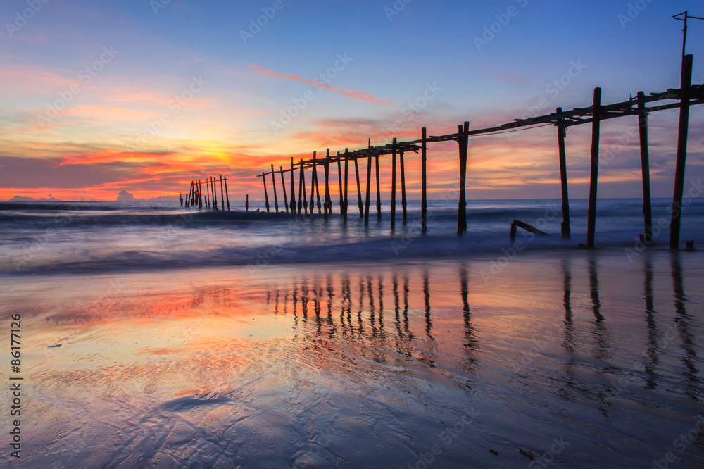 Broken wood bridge and waves crashing on sea at during sunset, Phangnga, Thailand