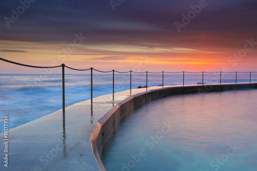 Sunrise seascape and rock pool in Bronte rock pool, Sydney, Australia.