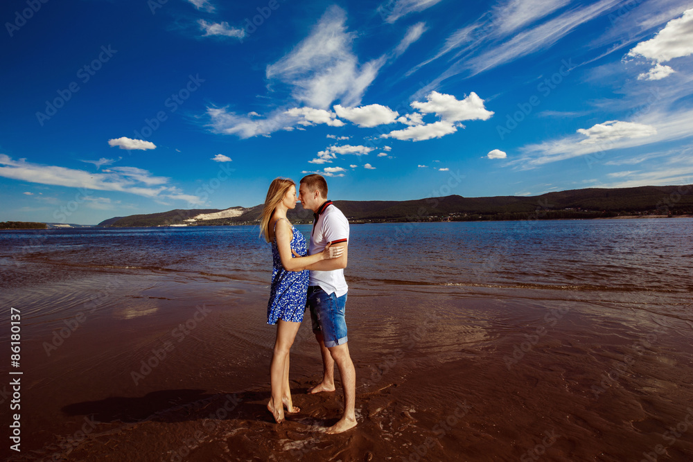 Beautiful happy couple is embracing outdoors at summer beach 