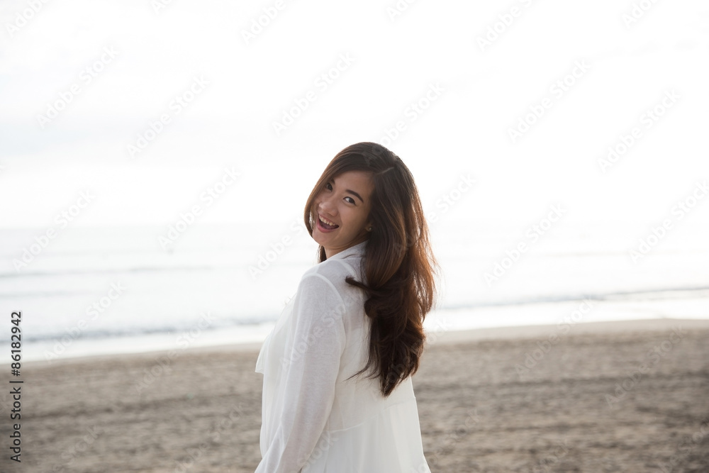 Asian woman smiling to camera, enjoying time on the beach Asian woman smiling to camera, enjoying time on the beach