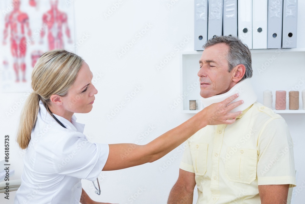 Doctor talking to patient wearing neck brace Doctor talking to patient wearing neck brace