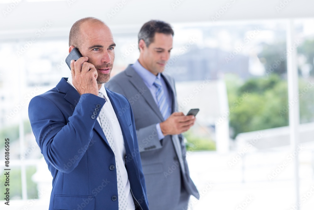 Business colleagues using phones Business colleagues using phones