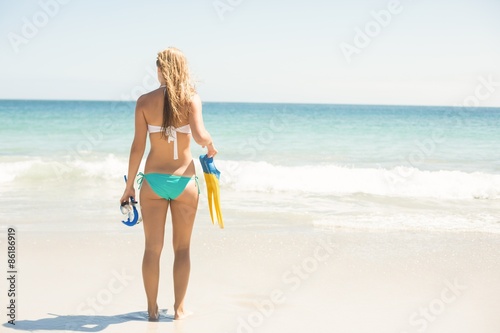 Wear view oh woman holding mask, scuba and fins 