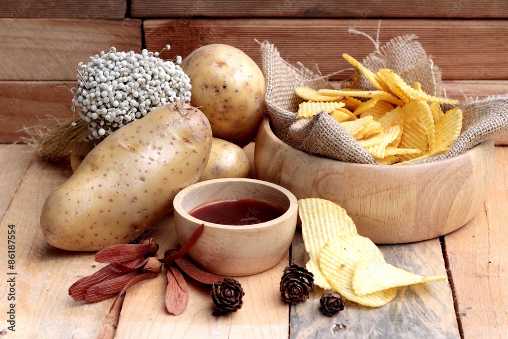 Potato chip and fresh potatoes on wood background Potato chip and fresh potatoes on wood background