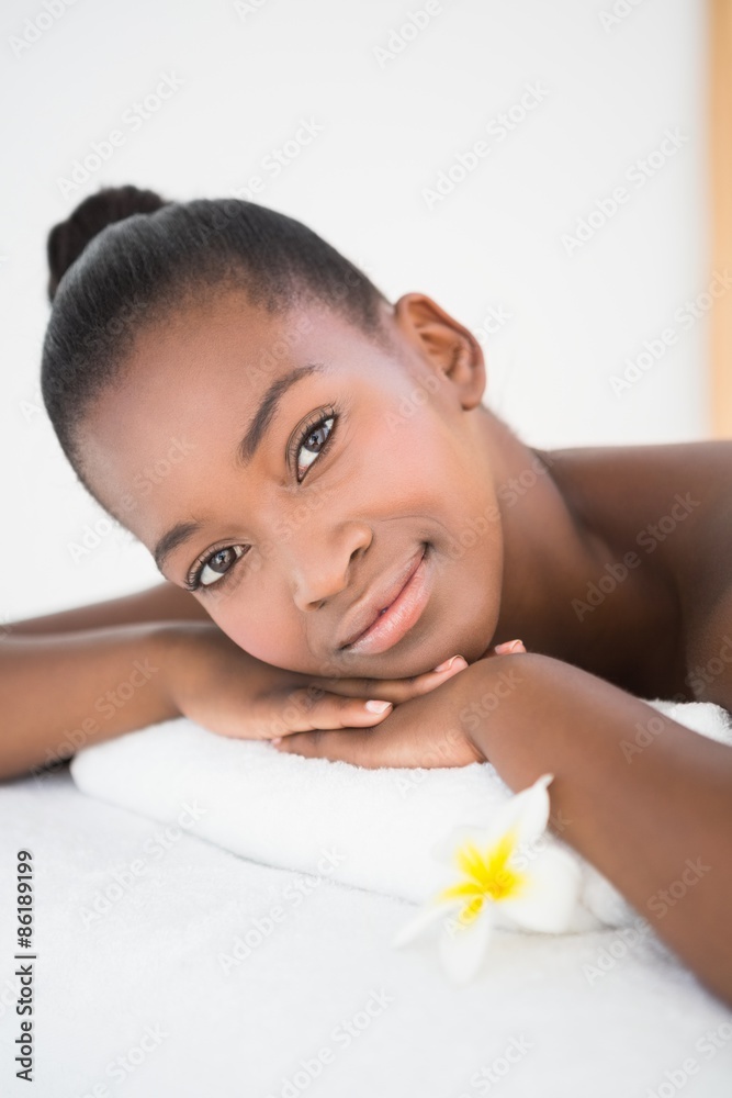 Pretty woman lying on massage table smiling at the camera Pretty woman lying on massage table smiling at the camera