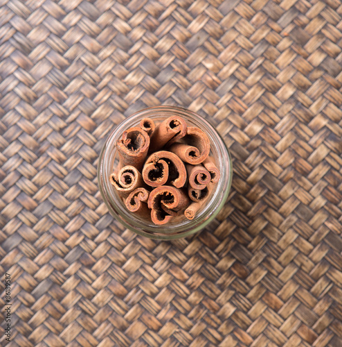 Cinnamon stick spice in a mason jar over wicker background