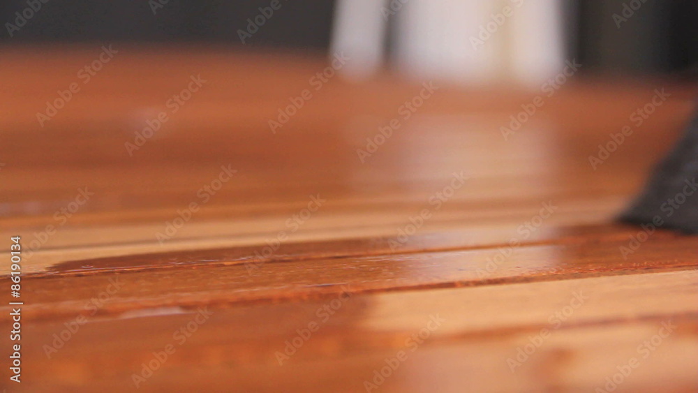 Paint brush painting a wooden table with varnish Paint brush painting a wooden table with varnish