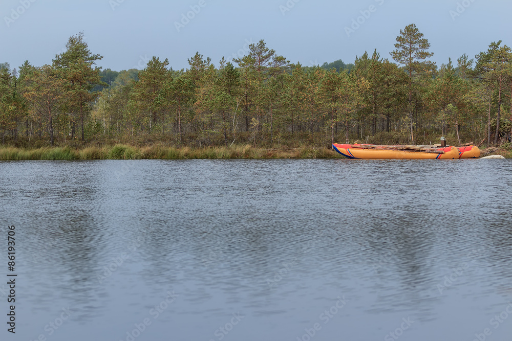 Obraz premium Sailing inflatable catamaran floating on forest lake water