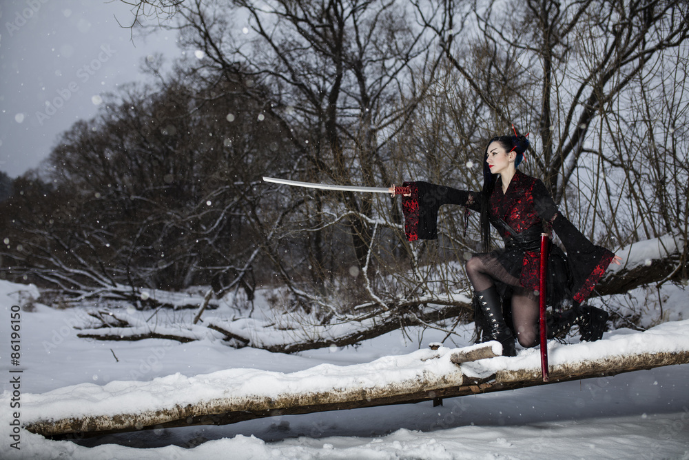 beautiful young girl in a suit of samurai on the frozen river