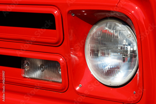 Headlight on a red 1960's antique truck in good condition