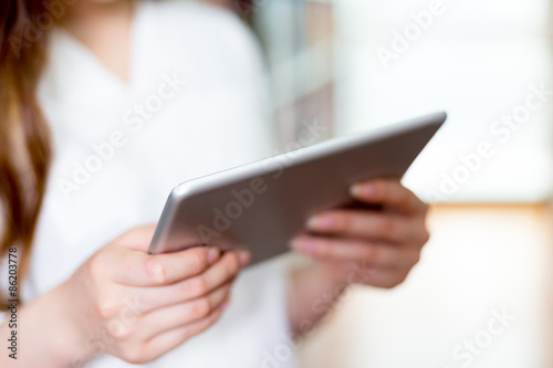 close up of hand touching tablet in library