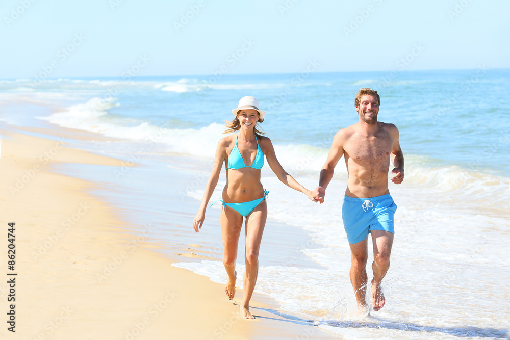 Couple having fun running on the beach