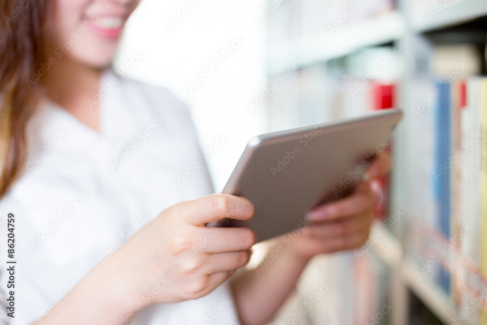 Asian beautiful female student using tablet in library Asian beautiful female student using tablet in library