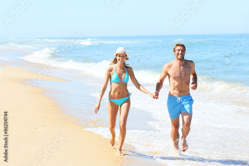 Couple having fun running on the beach