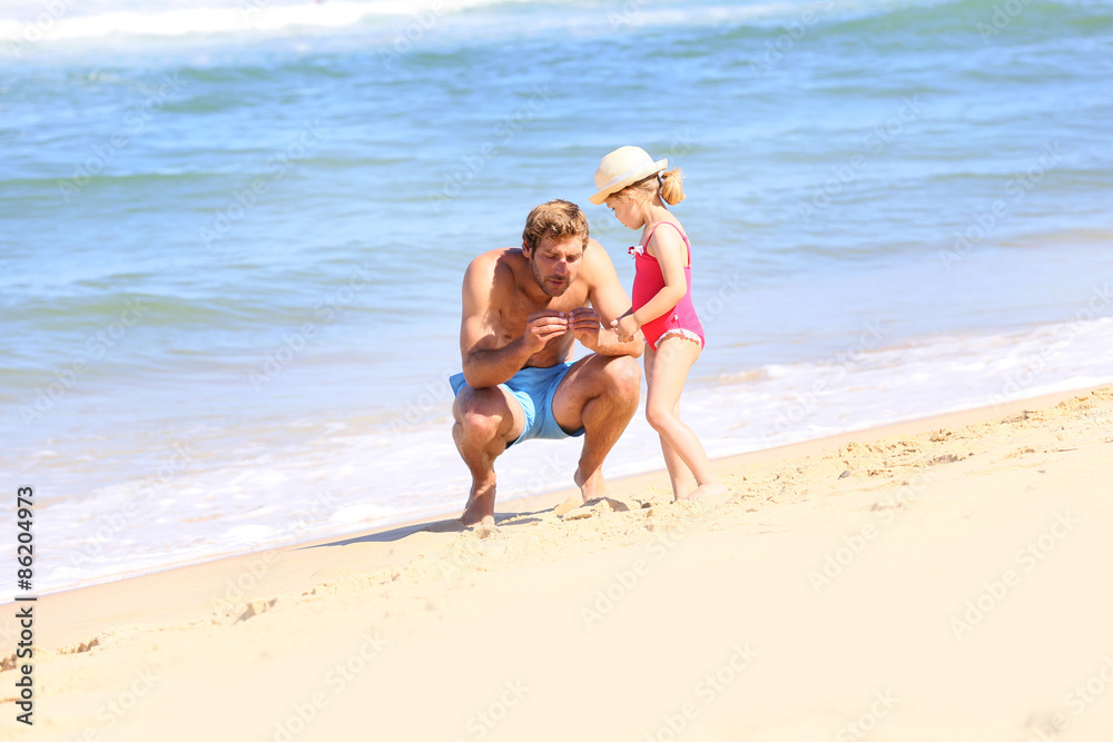 Daddy with little girl playing on the beach