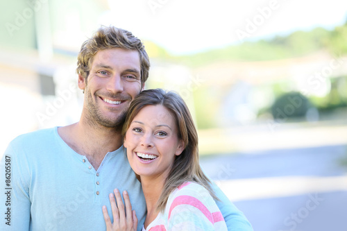Portrait of cheerful couple standing in new property walkway