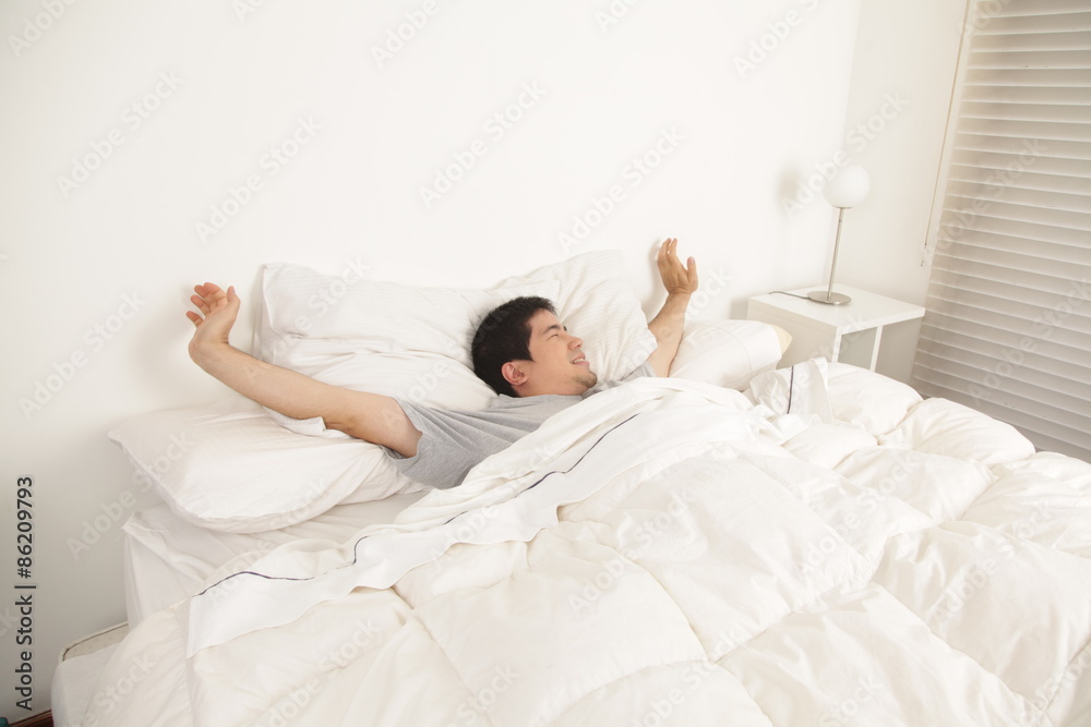 Man stretching in his bed