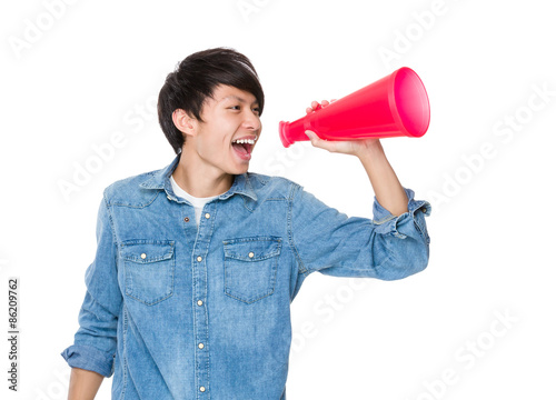 Young man yell with loudspeaker