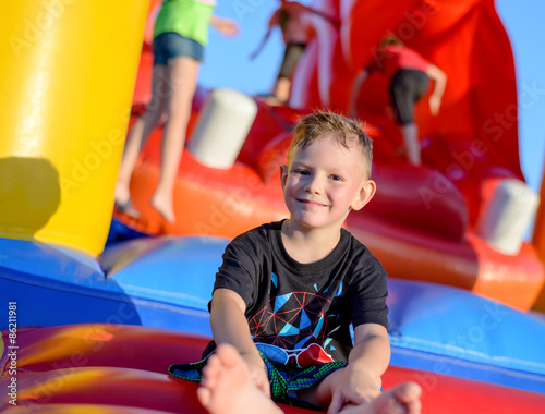 Smiling little boy sitting on a jumping castle