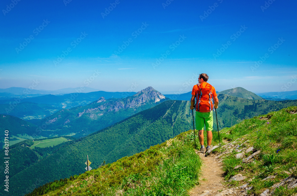 Man and orange backpack on mountain trail Slovakia